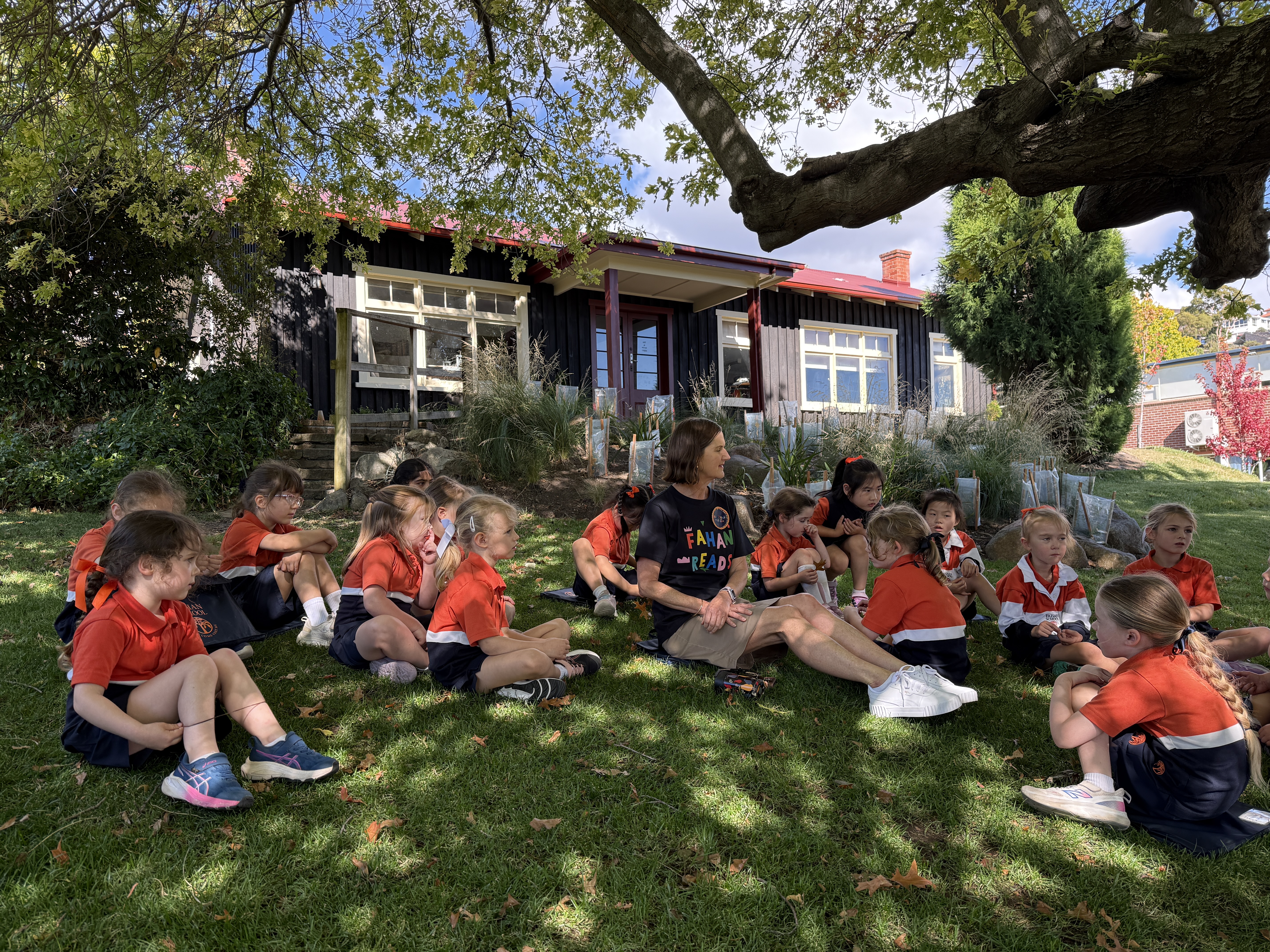 Fahan teacher reading with Junior School students in the garden