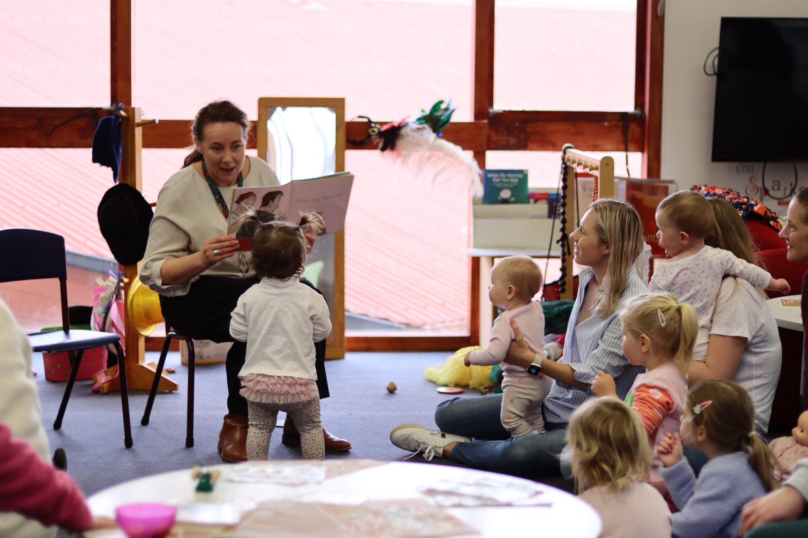 An educator reading a story to children at Little Sparks