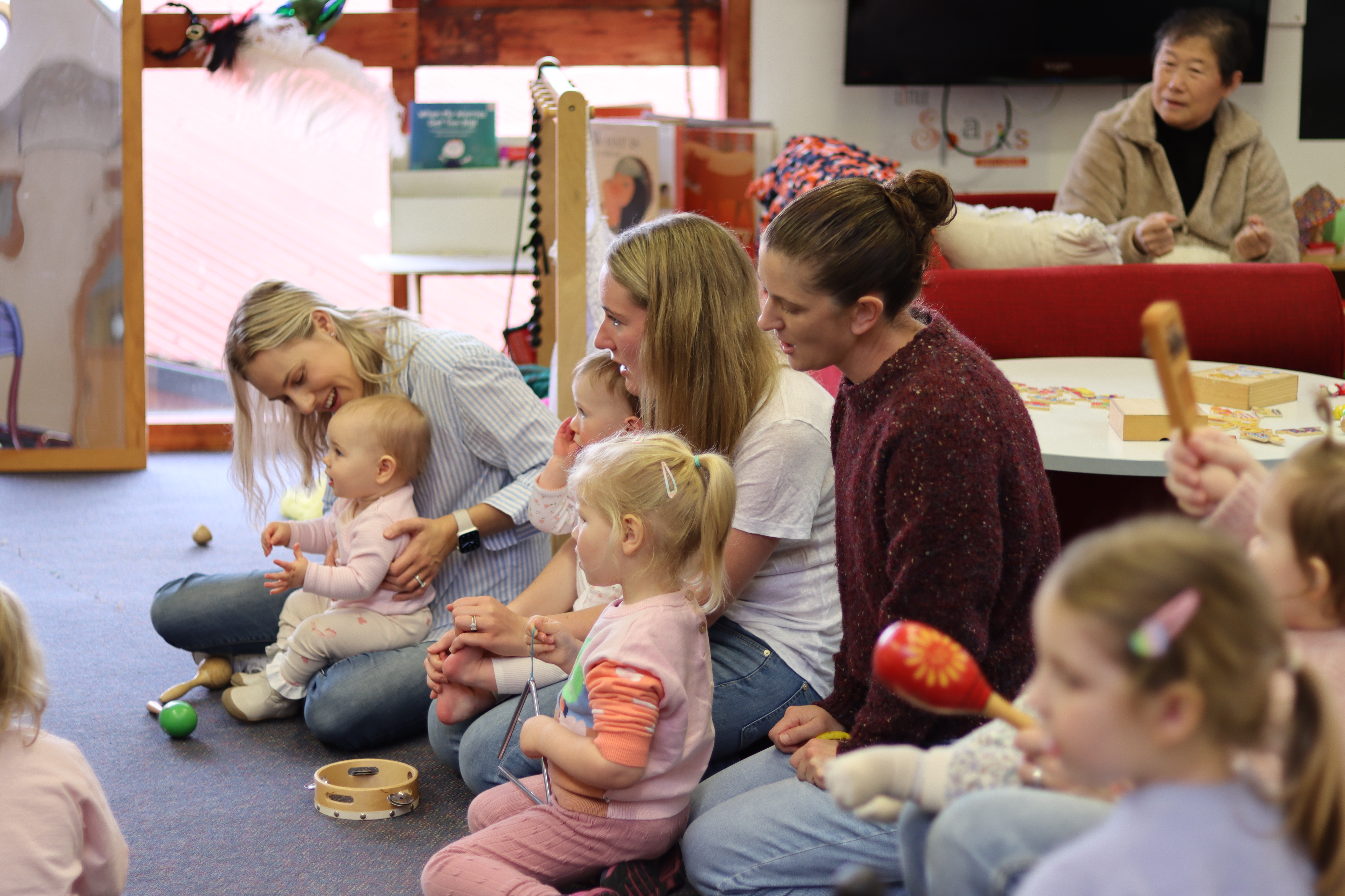 Families and children playing musical instruments together at Little Sparks