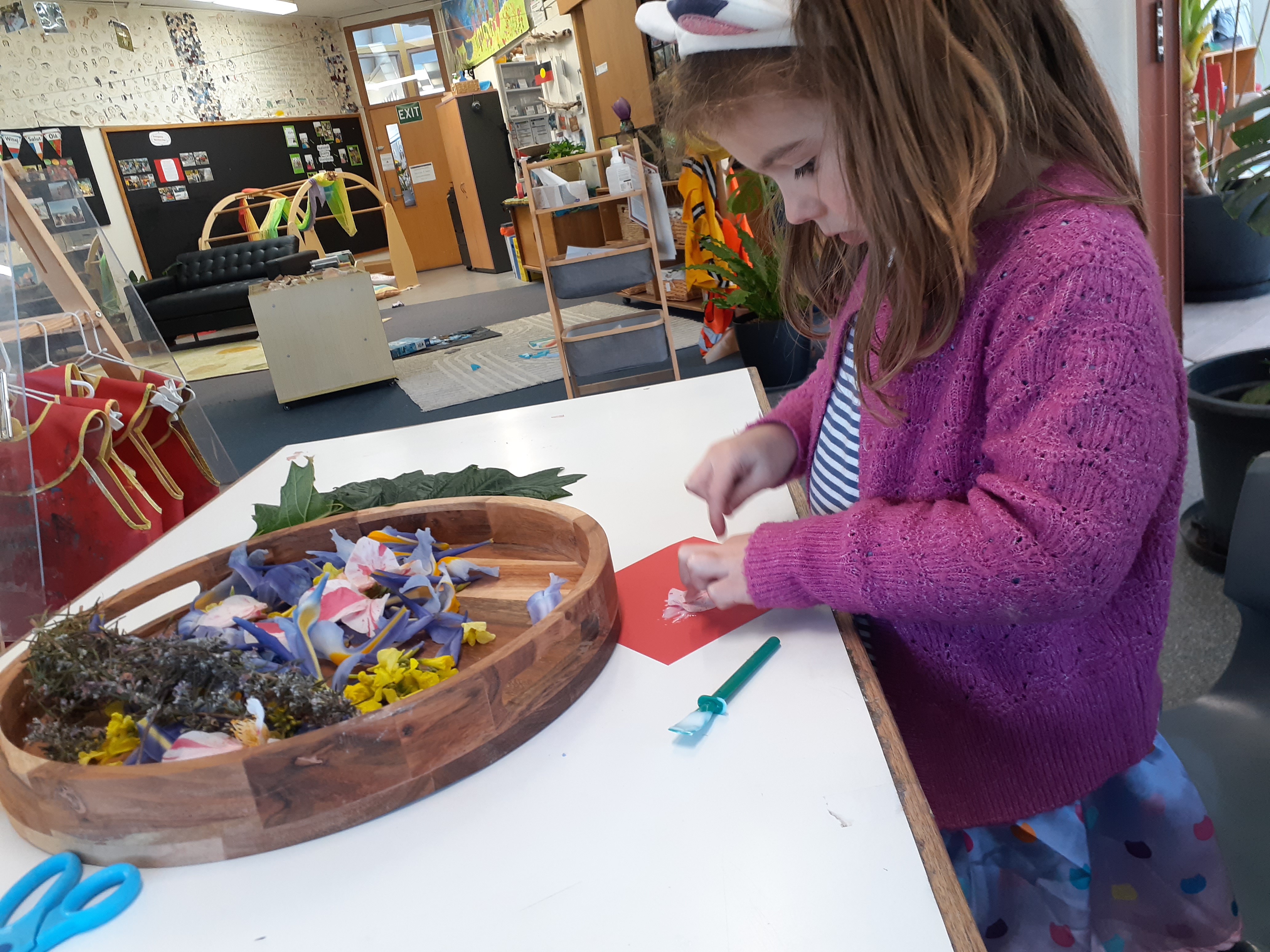 A Pre-Kinder child exploring flower petal craft